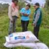 The Second Generation: Katerine’s Story Returning to Coffee Farms Katerine and Community Promoter Alejandro Llanten distribute home garden materials to beneficiary Eliecer Campo of Asodesam in Baraya (1)